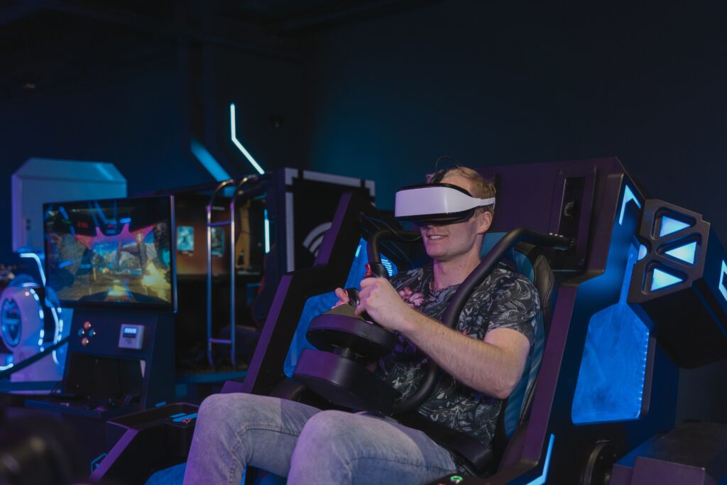 A man enjoying a virtual reality gaming session using a VR headset in a tech setting